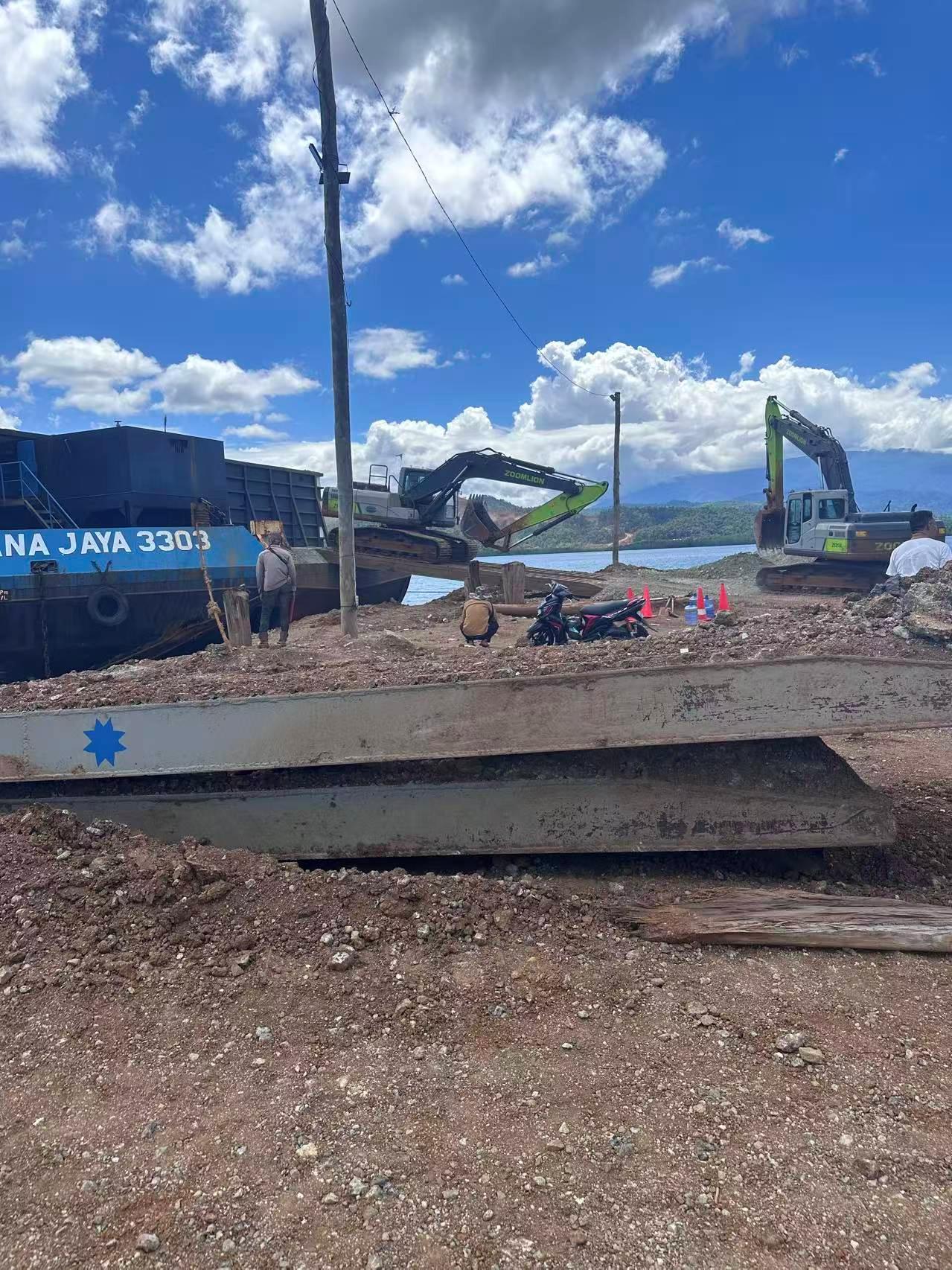 Alat berat dan tongkang di dermaga pemuatan
